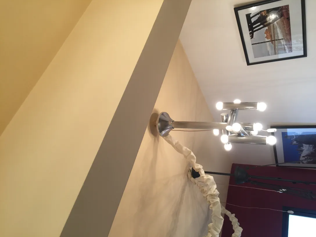 Antique hanging lamp with multiple bulbs in a modern setting.