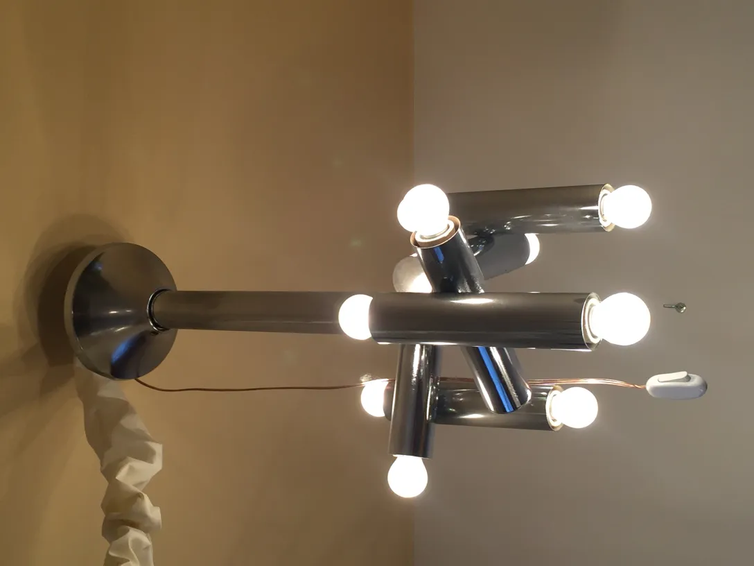 Lampada a sospensione antica con diverse lampadine tubolari che illuminano una stanza