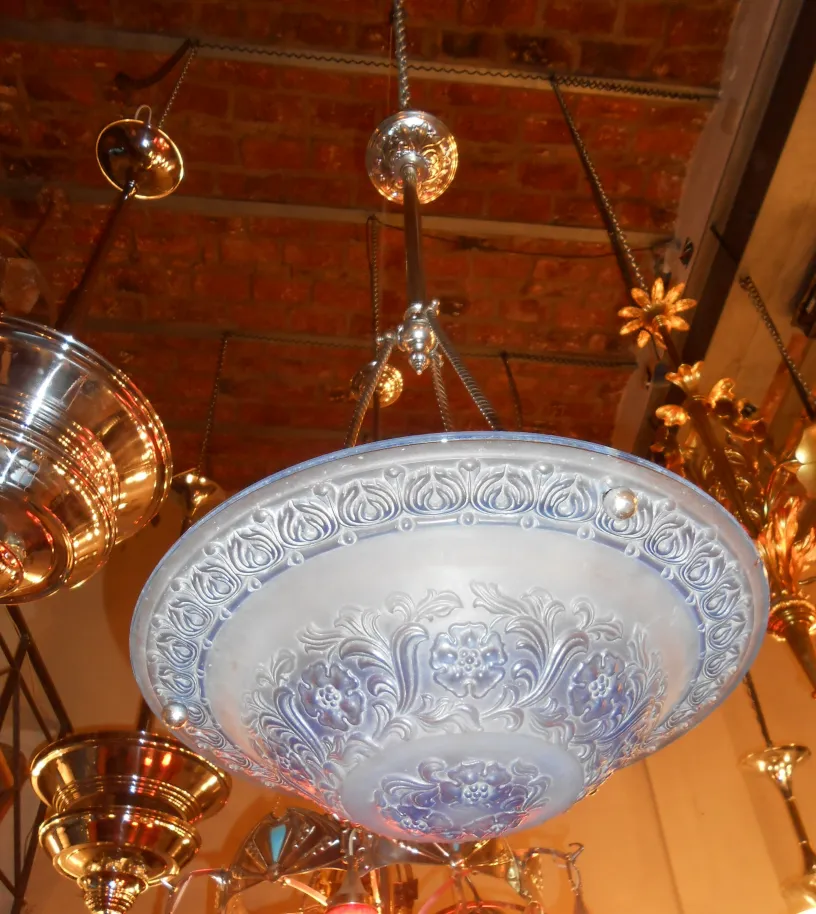 Lustre ancien avec un design floral à la base.