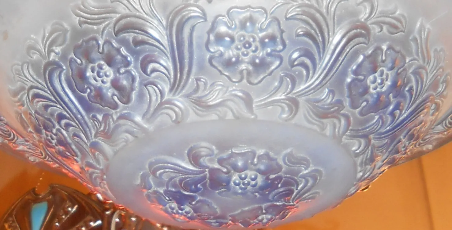 Antike Hängelampe mit floralem Design in sanften Tönen, elegantes Ambiente.