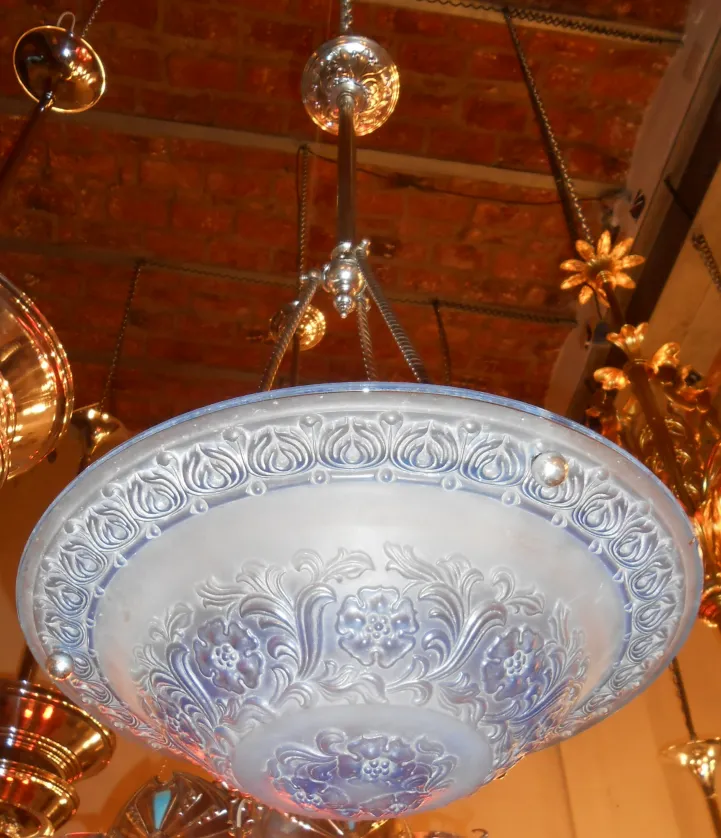 Lustre ancien avec motifs floraux et ornements.