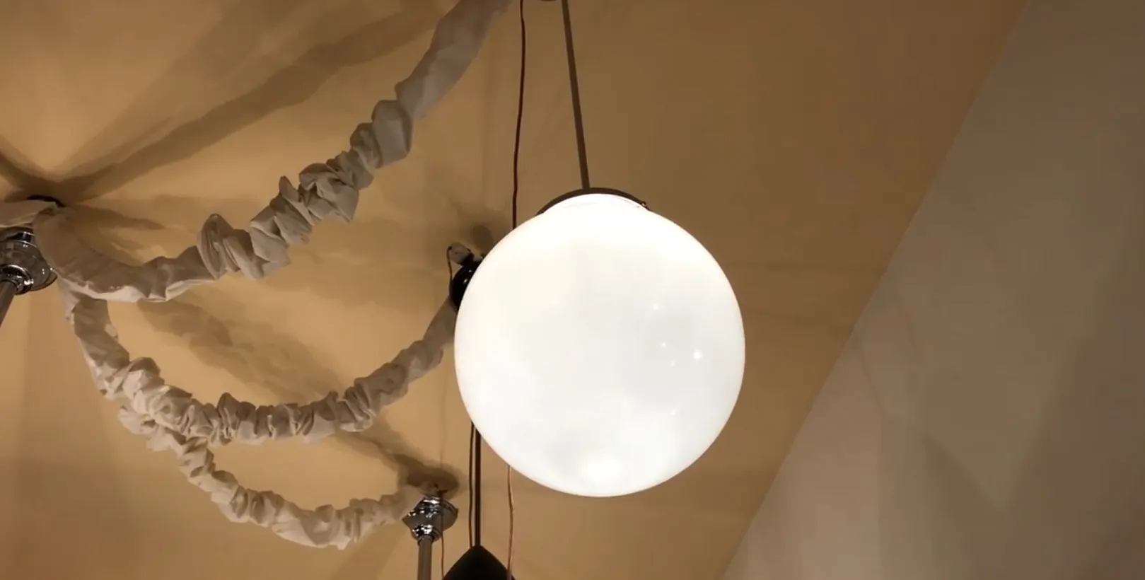 Lampada de teto antiga com esfera branca e detalhes no ambiente