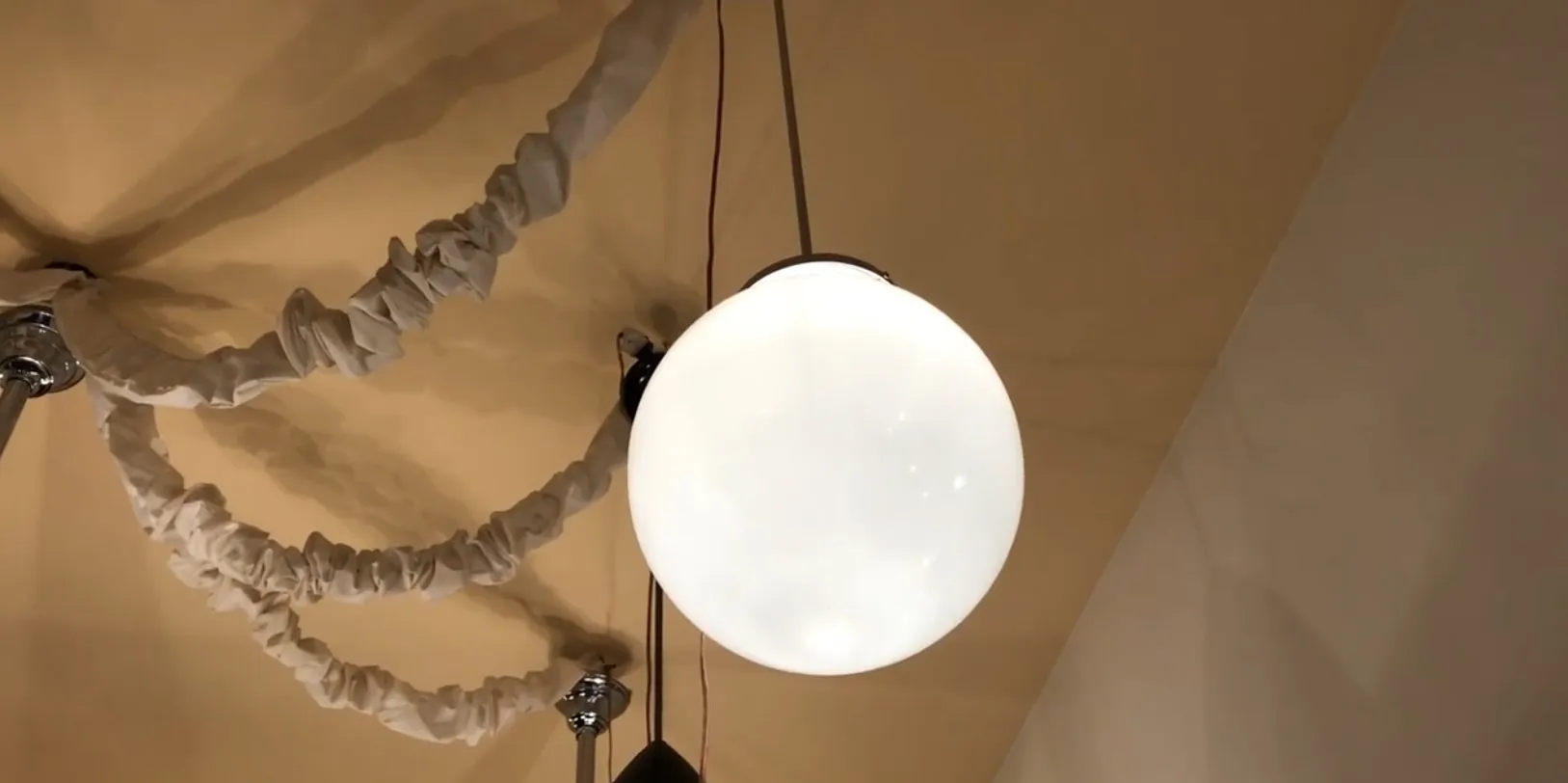 Lustre antique avec sphère blanche, ambiance chaleureuse.