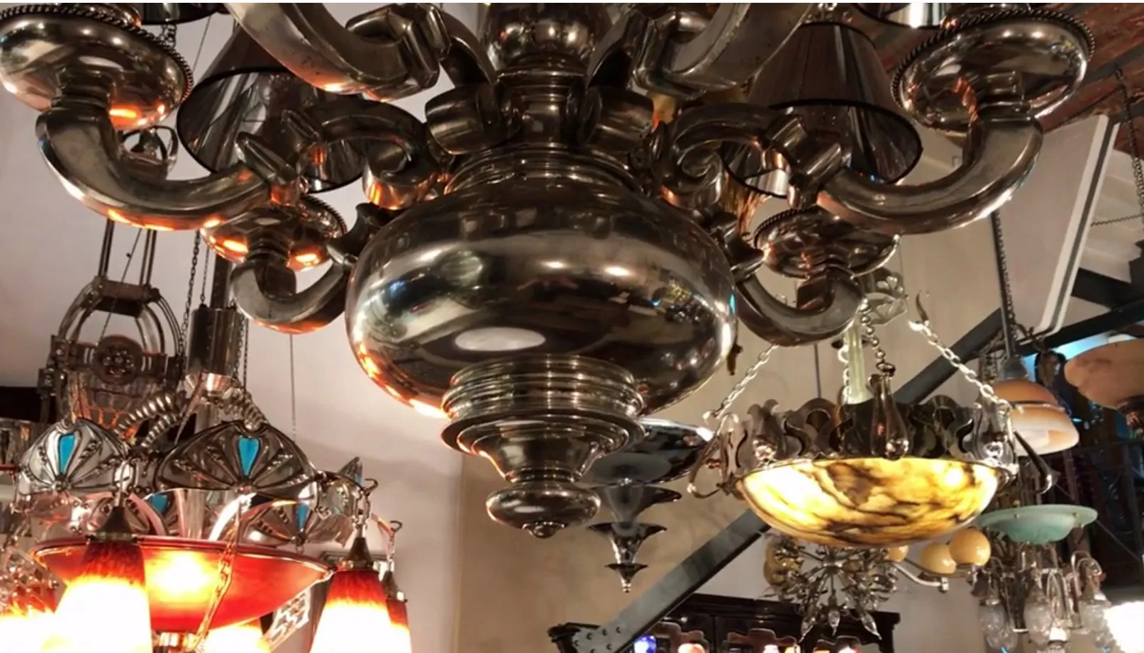 Lustre ancien brillant avec des détails décoratifs. Ambiance chaleureuse avec d'autres lampes.