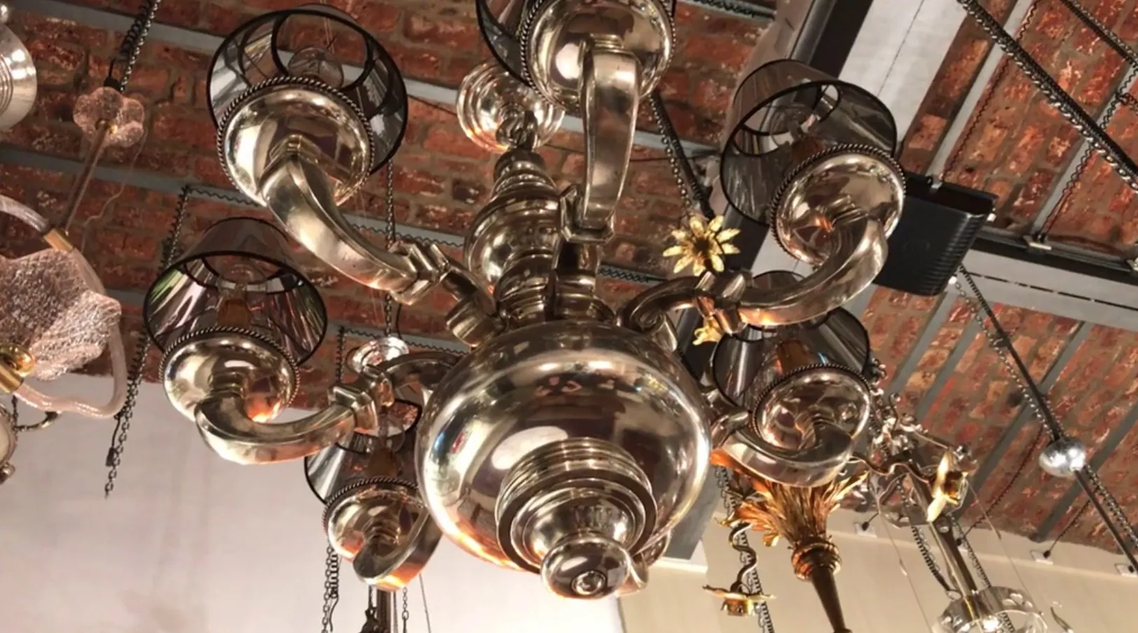 Старинная подвесная лампа с элегантными руками и золотыми деталями, уютная атмосфера.