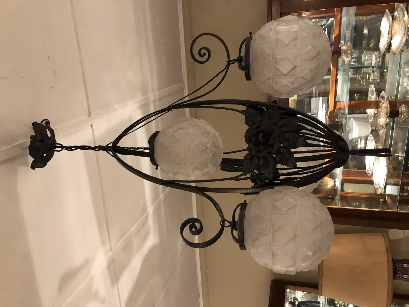 Antike Hängelampe mit runden Glühbirnen und floralen Designs in einem eleganten Ambiente.