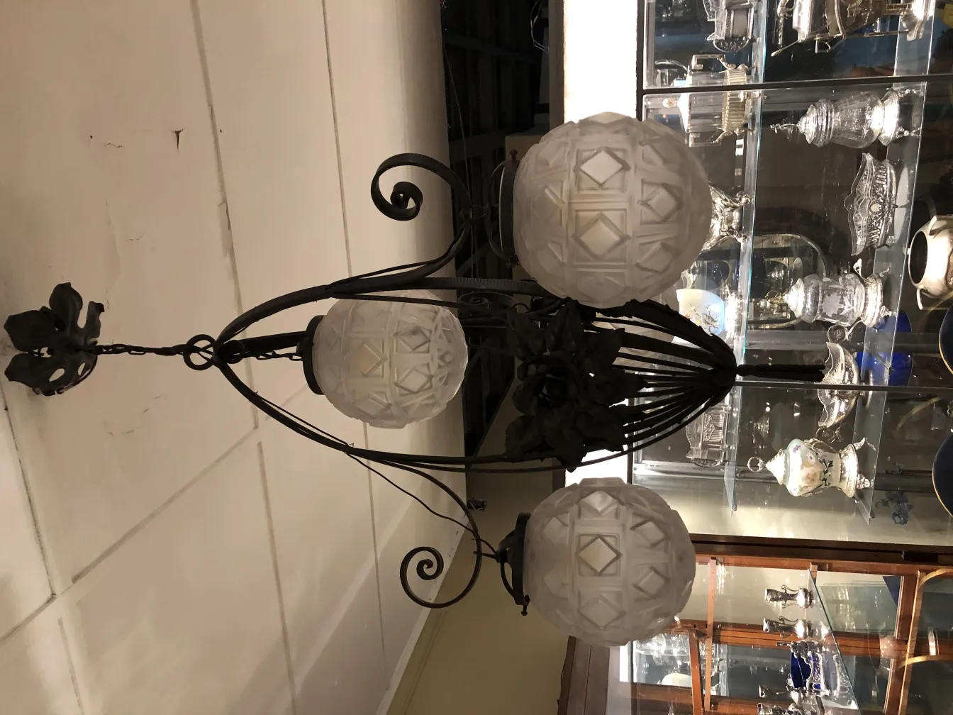 古いハンギングランプに3つの白いガラスの球体があり、エレガントな設定です。