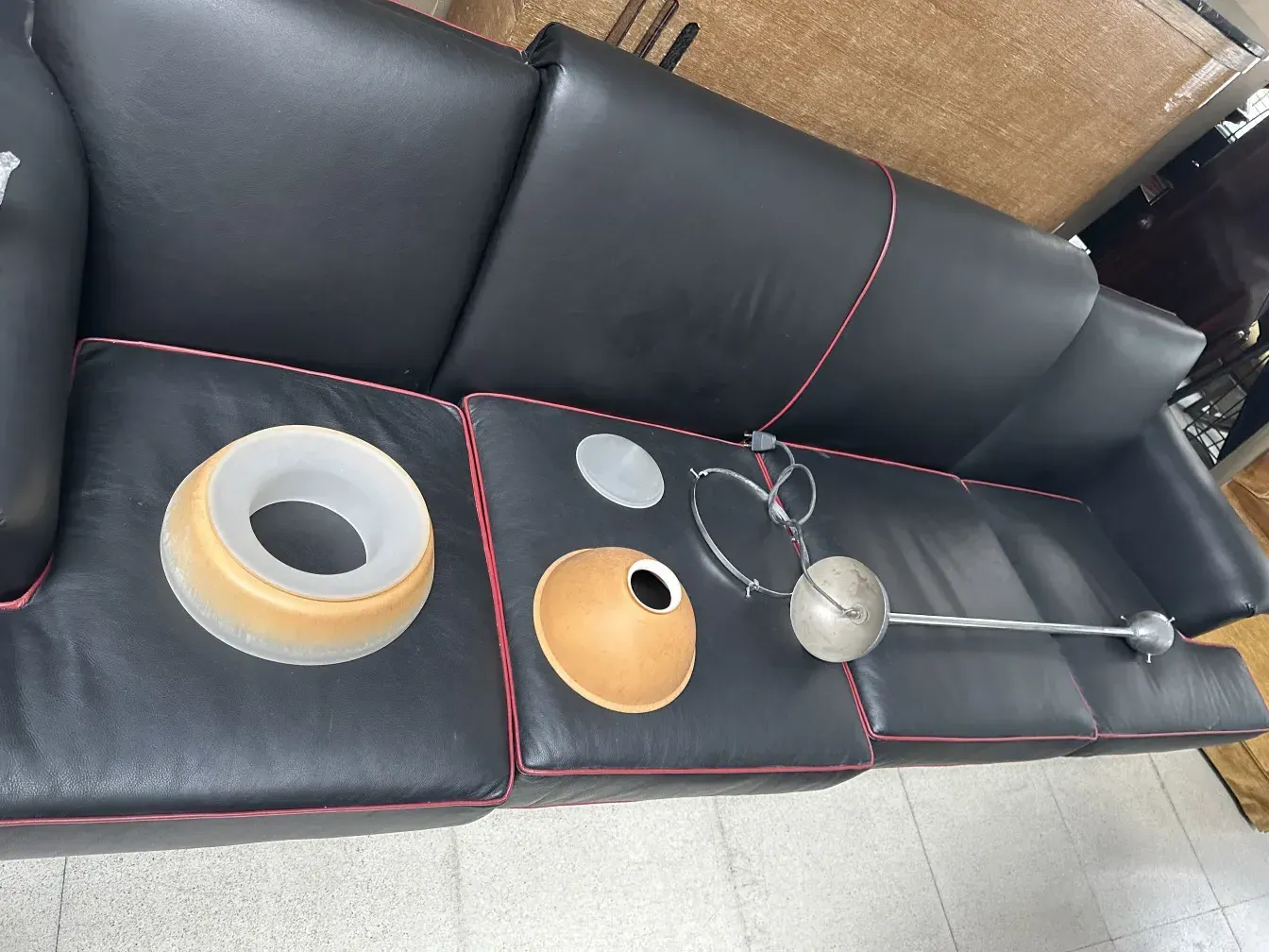 黒いソファの上の古いハンギングランプの部品