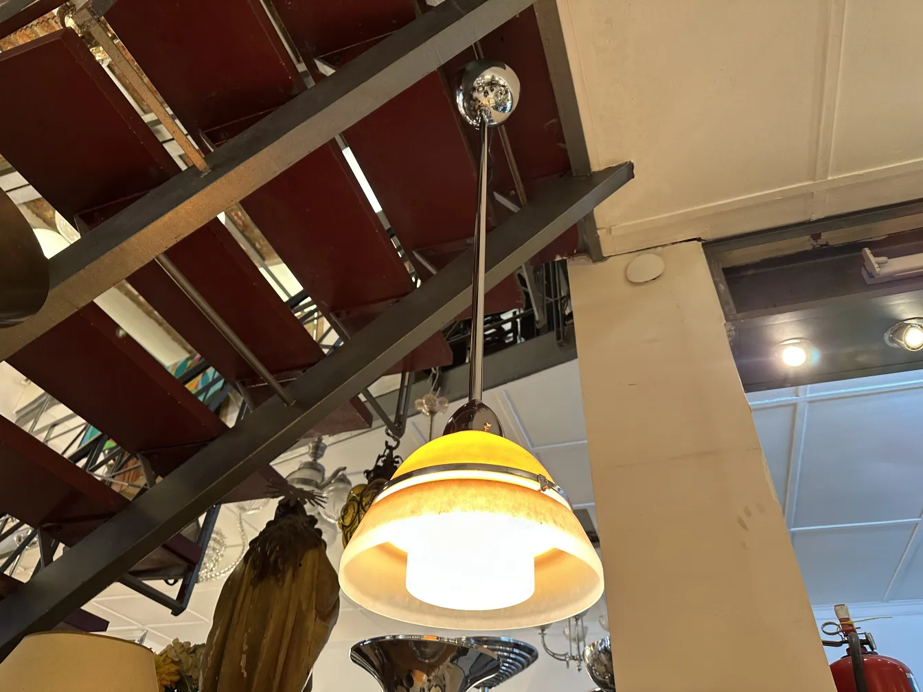 Antiga lâmpada de teto de design clássico, iluminando um ambiente decorativo variado.