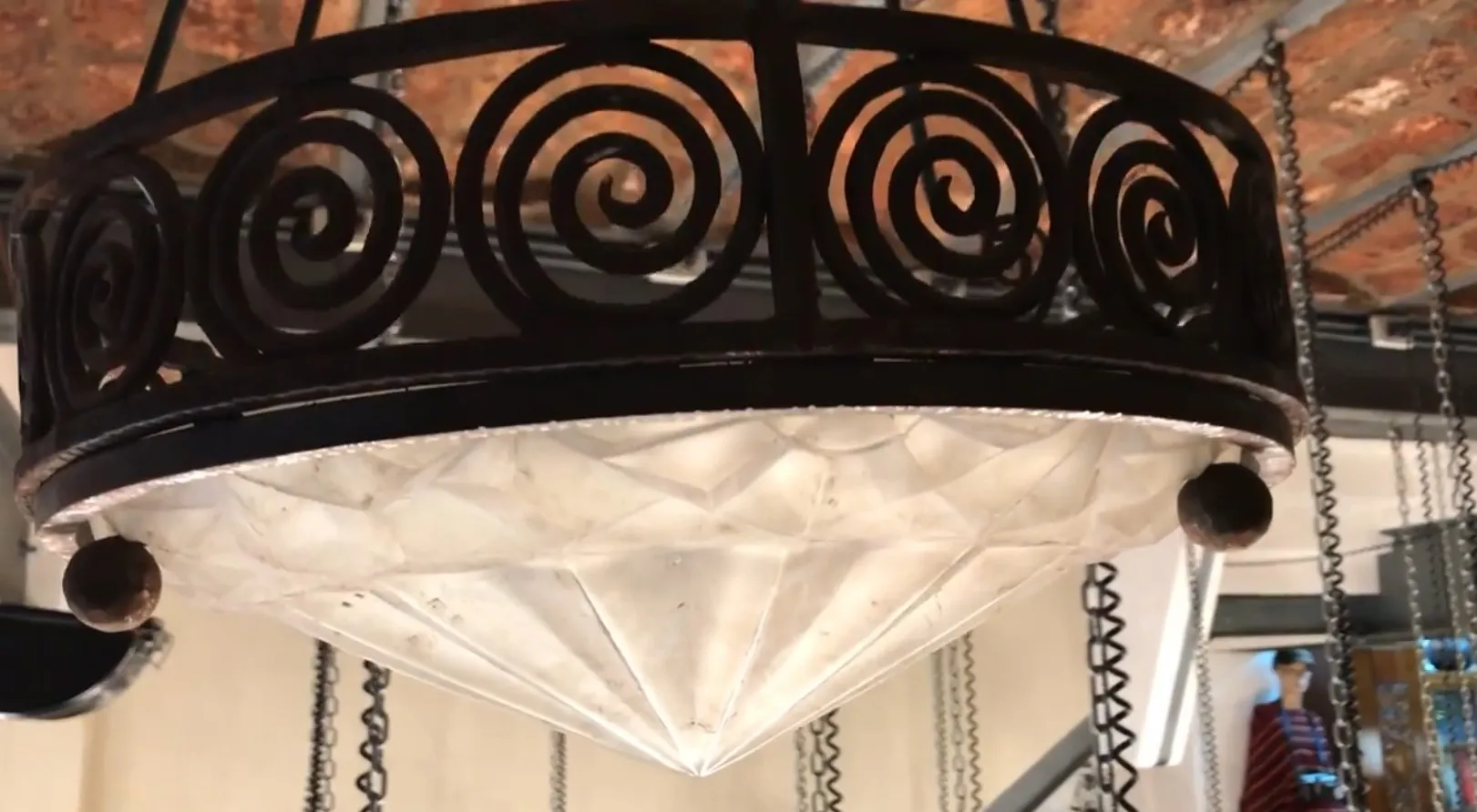 Lámpara de techo antigua con diseño en espiral y cristal. Ambiente acogedor.