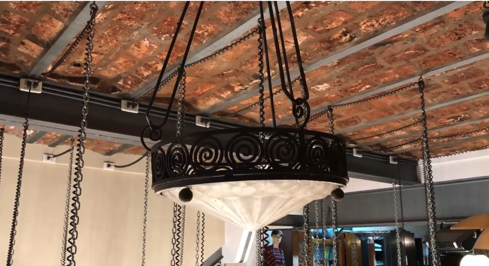 Lampada a sospensione antica con design ornamentale elegante, in un ambiente accogliente.