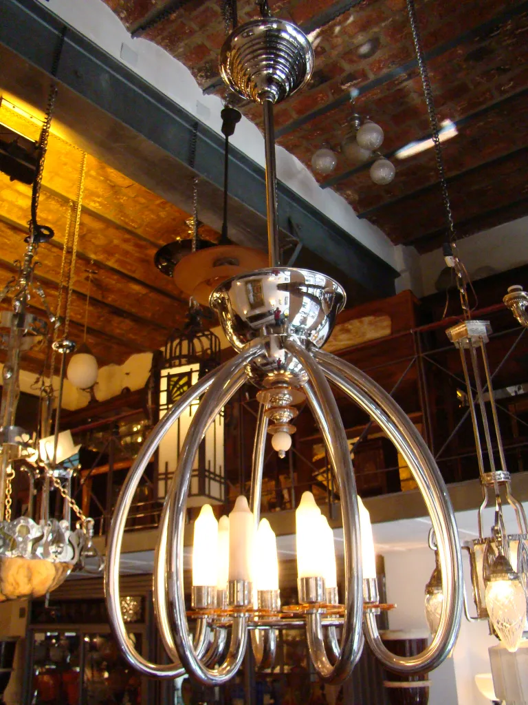 Lustre ancien avec un design élégant et 5 ampoules allumées dans un cadre confortable.