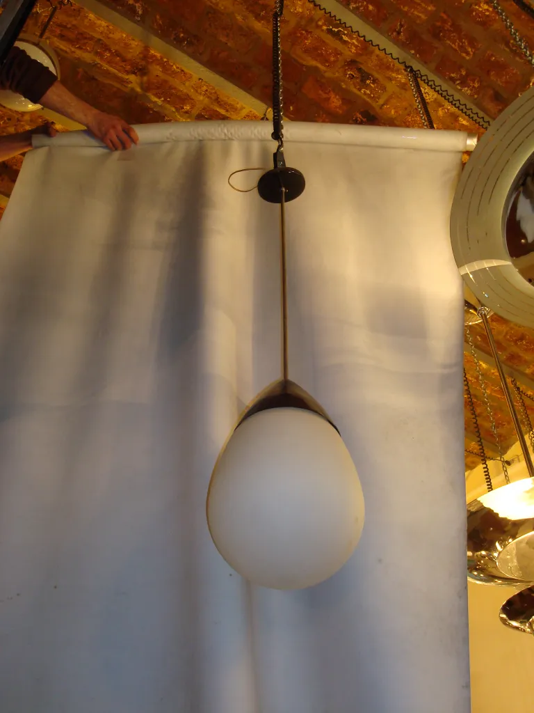 Lampada a sospensione antica con globo di vetro in un ambiente accogliente.