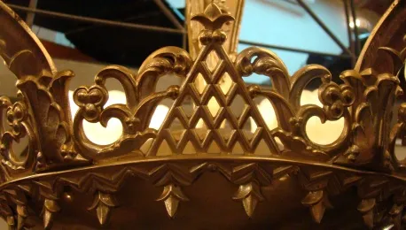 Antique hanging lamp with golden details against a light background, surrounded by a cozy environment.