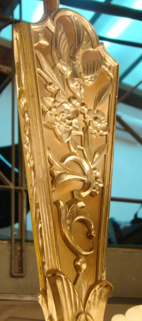 Lampada a sospensione antica con un intricato design floreale in un ambiente elegante.