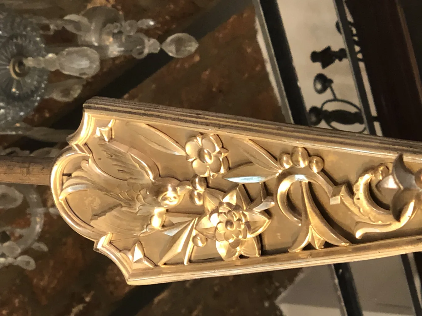 Lampada a sospensione antica con dettagli floreali elaborati, ambiente caldo.