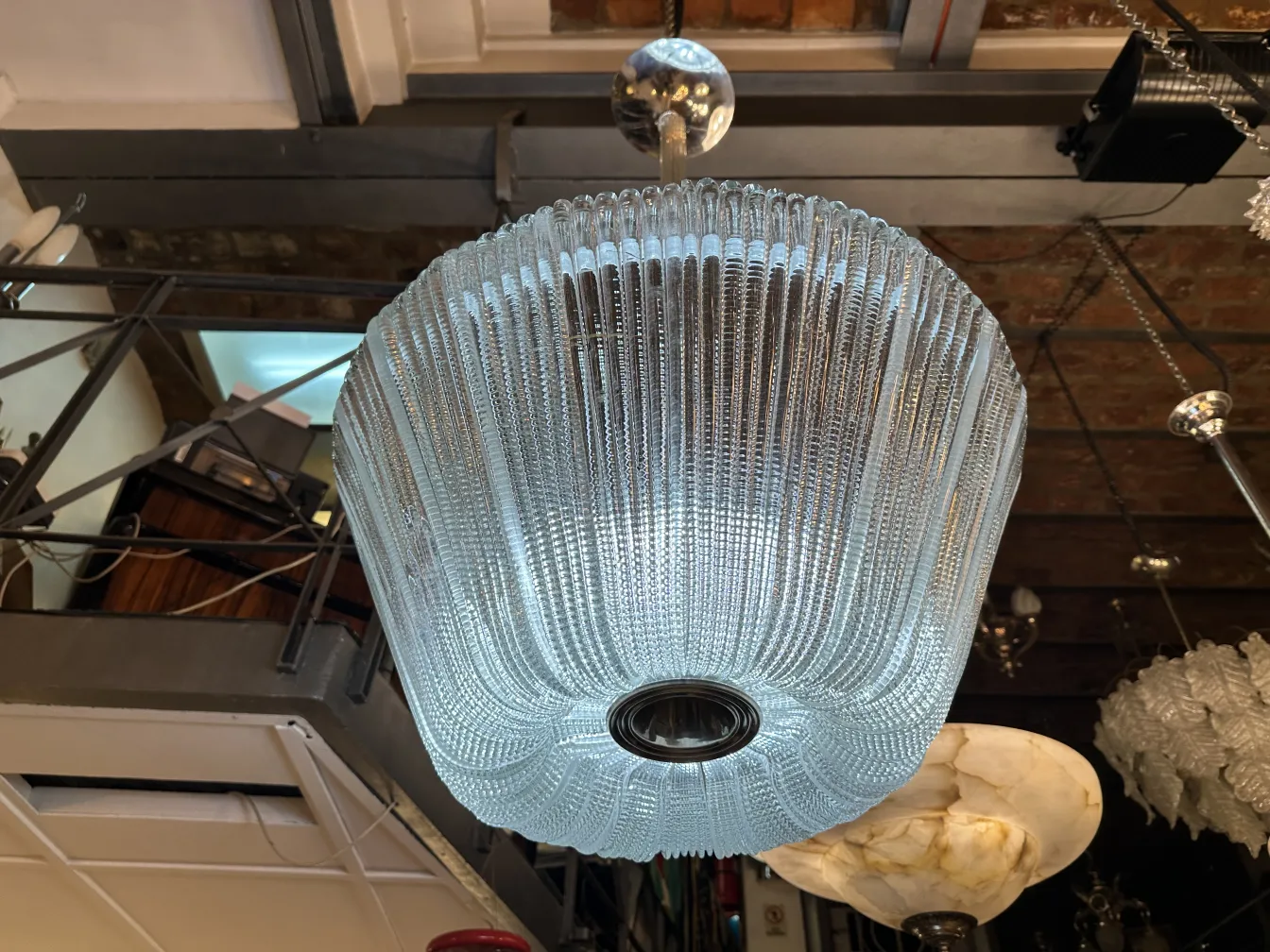 Antique hanging lamp with modern design, paolo venini style, illuminating a cozy atmosphere.