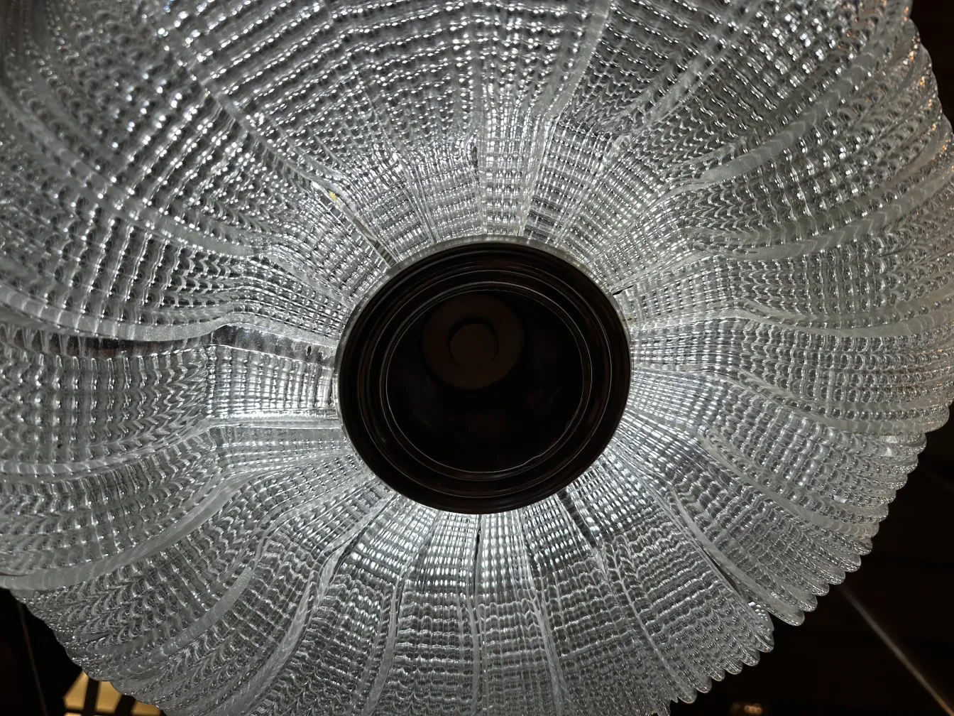 vista superiore di una lampada a sospensione antica con dettagli eleganti e luce brillante.