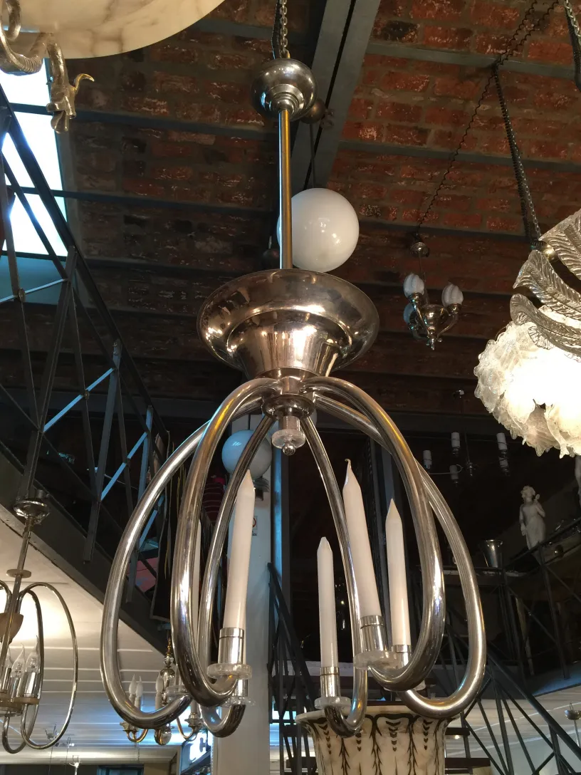 Antique hanging lamp with a flowing, elegant design in a cozy setting.