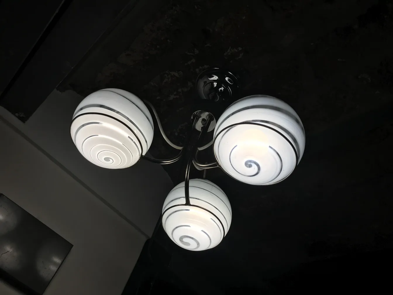 Lampada de teto antiga com tres bulbos brancos em espiral