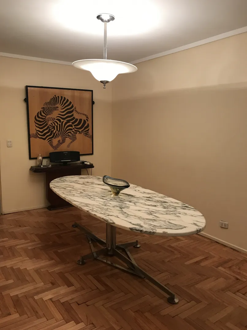 Lámpara de techo antigua en un salón con mesa ovalada