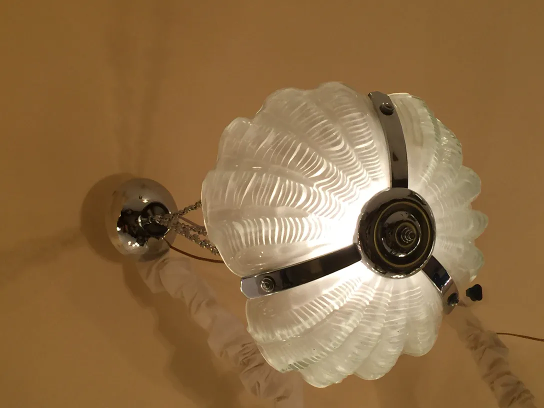 Lâmpada de teto antiga com design decorativo em forma de flor, iluminando um ambiente acolhedor.