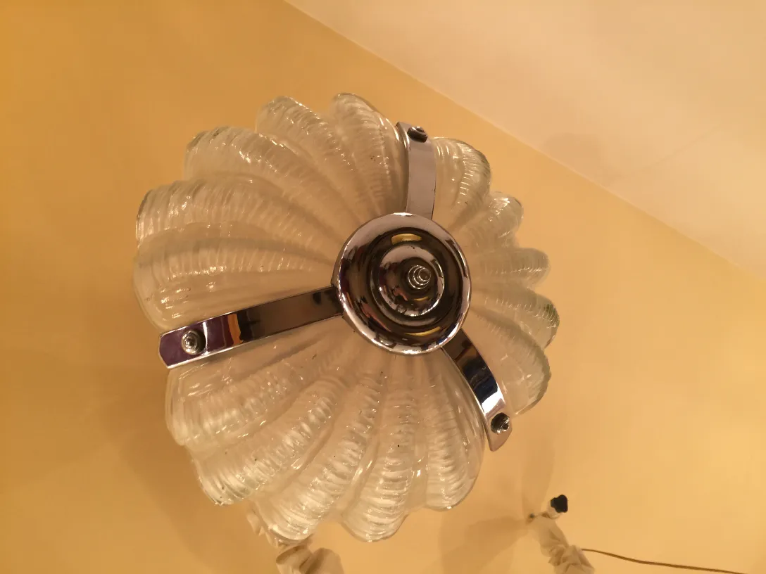 Antique hanging lamp with wavy glass and shiny finish in a warm atmosphere.