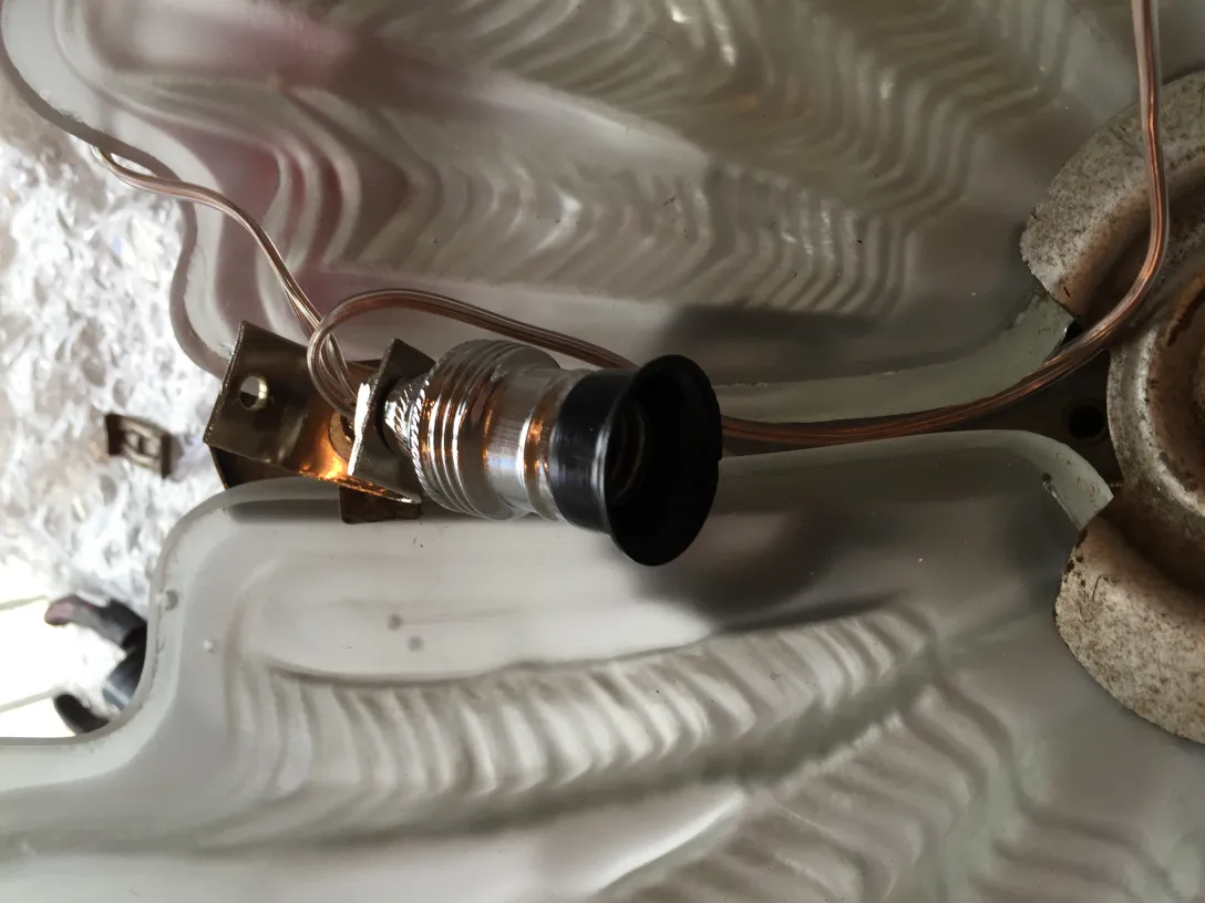 Detalhe de uma lâmpada de teto antiga com sistema elétrico.