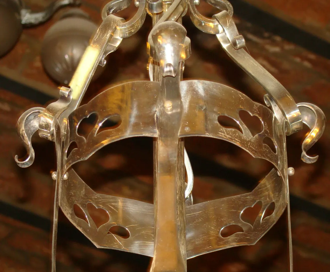 lustre antique avec des détails décoratifs en forme de cœur dans un cadre rustique