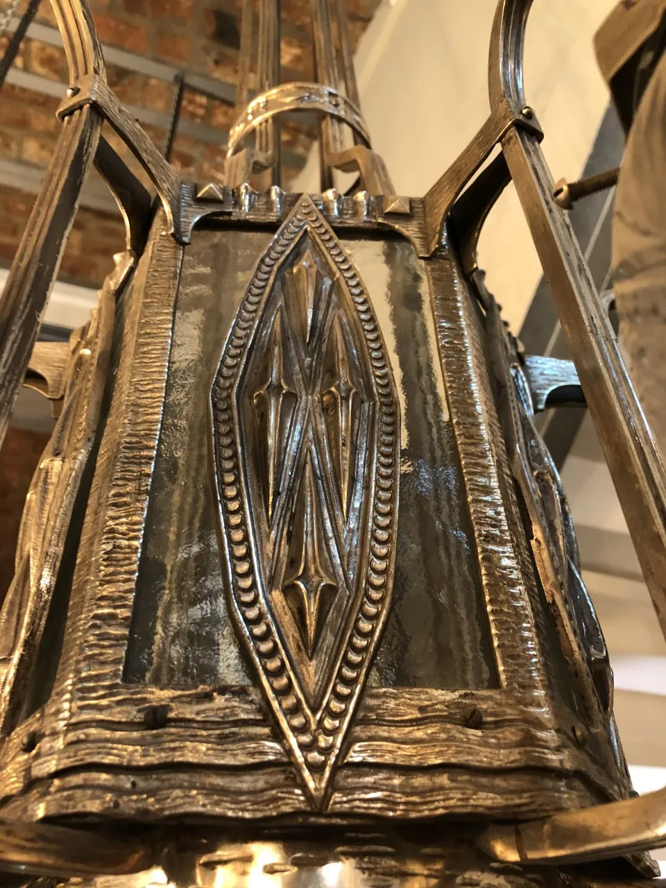 Lustre antique avec des détails en métal, dans un cadre vintage.