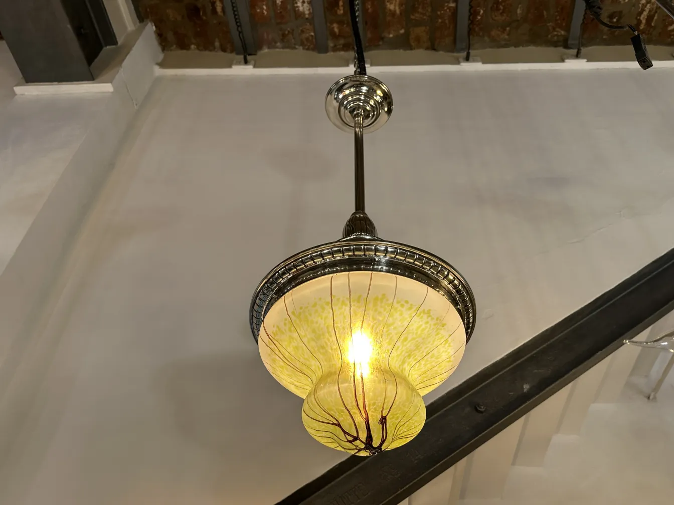 Lámpara de techo antigua con detalles coloridos y luz cálida en un ambiente acogedor.