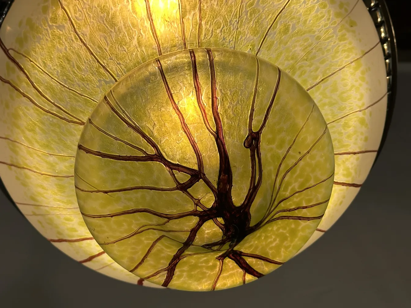 Lampada a sospensione antica in vetro con design naturale in tonalità gialle, che illumina dolcemente lo spazio.