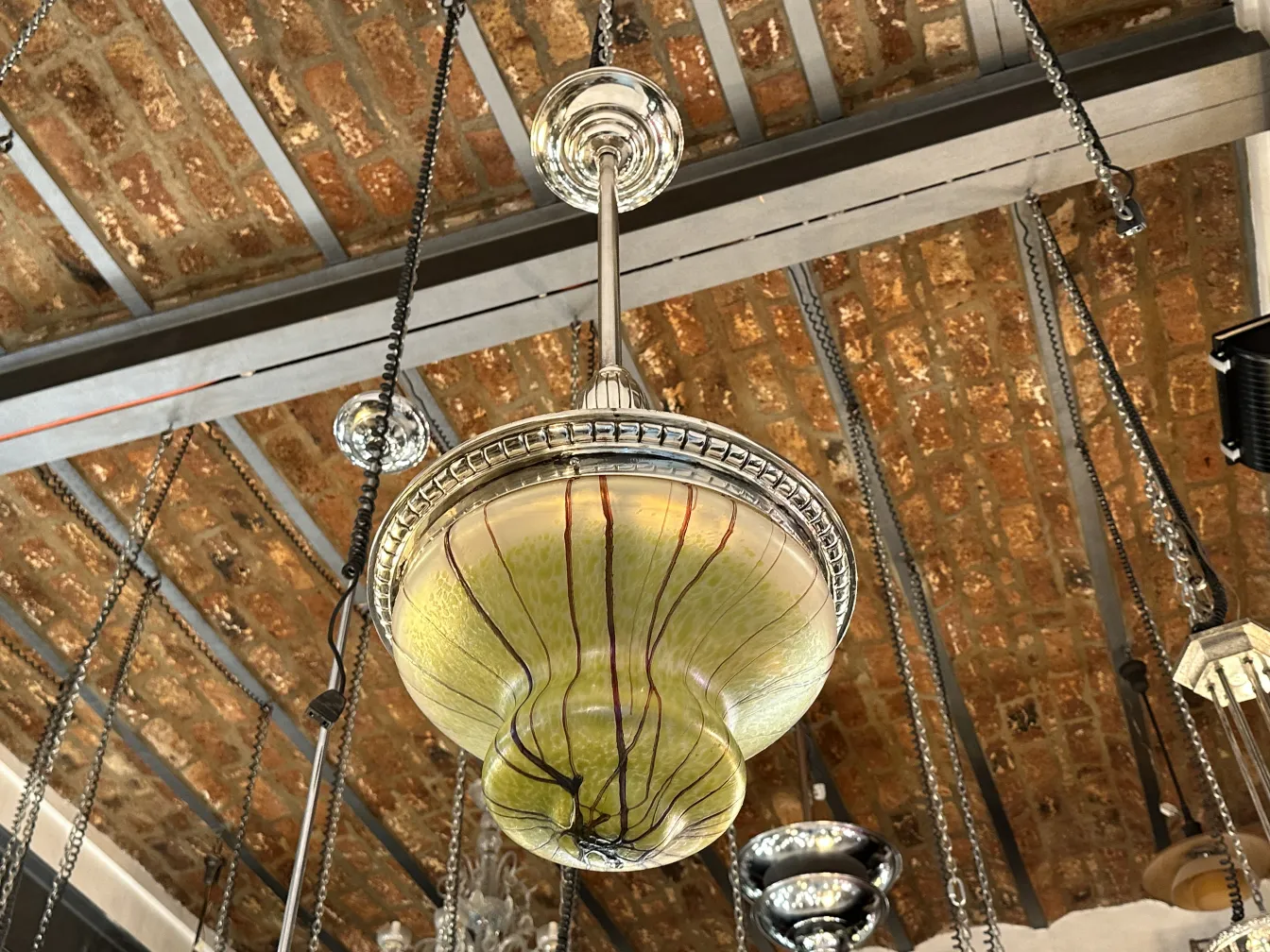 Lámpara de techo antigua con diseño artístico, color verde y detalles en el ambiente.