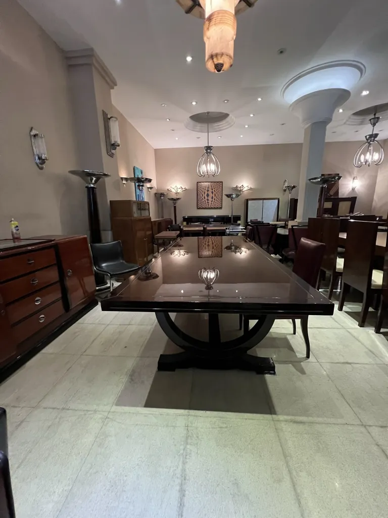 Lustre ancien suspendu dans une salle à manger élégante avec une grande table