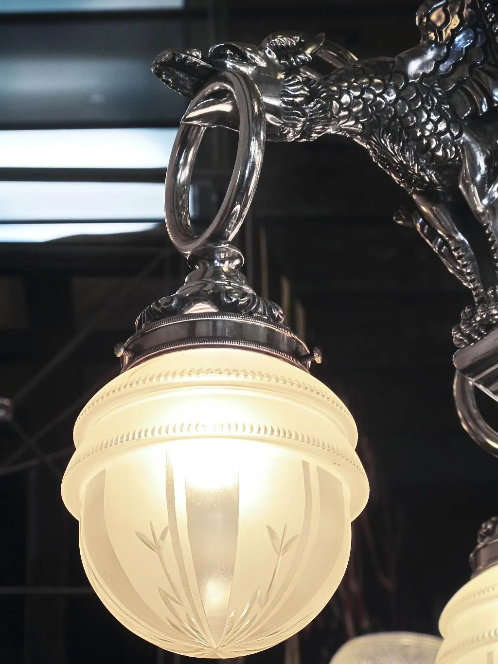 Antique hanging lamp with an elegant opaline globe, featuring metal decorative details.