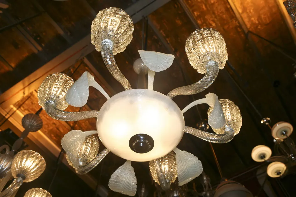 Lustre ancien avec un style décoratif et des bras courbés, illuminant un cadre élégant.