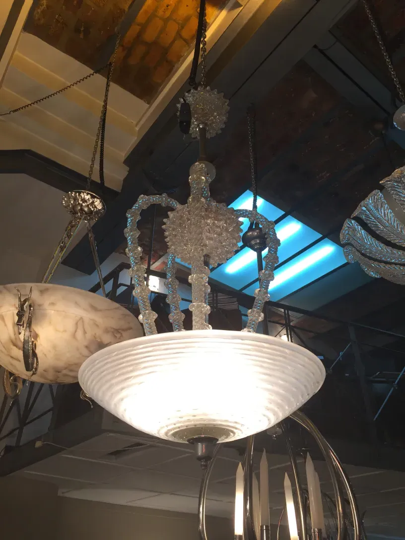 Lampada a sospensione antica con dettagli decorativi, ambiente elegante.