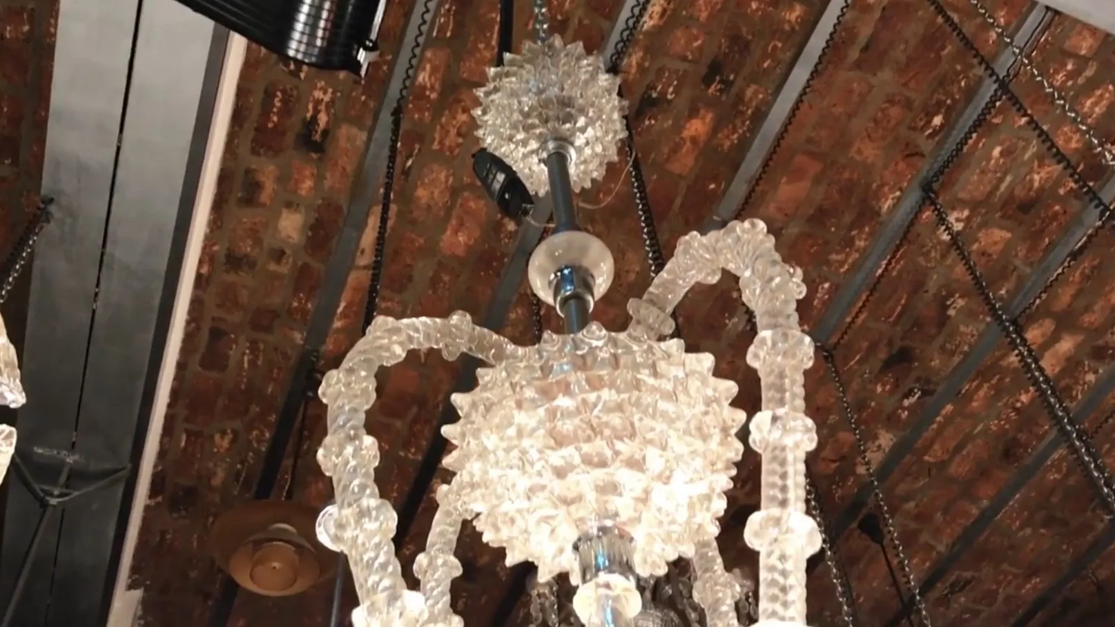 Lâmpada de teto antiga com formas decorativas em vidro. Ambiente rústico.