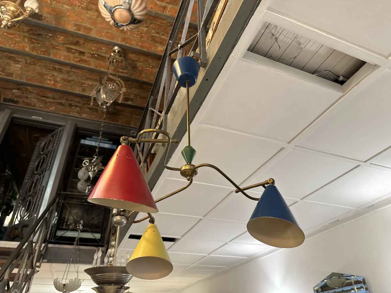 lampada a sospensione antica con tonalità rosse, blu e gialle in un ambiente vintage