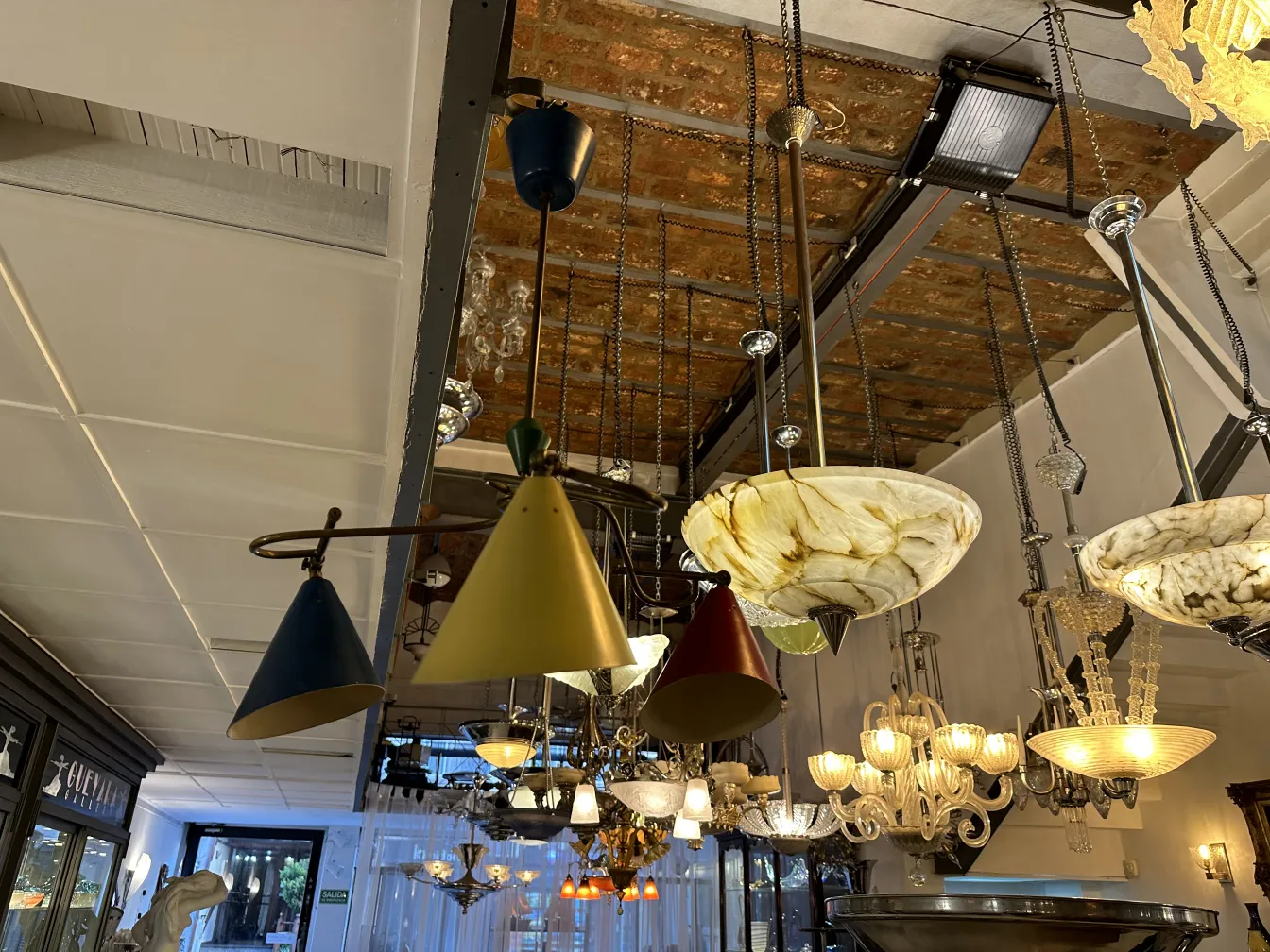 Lampada a sospensione antica e colorata in un elegante negozio con vari oggetti decorativi.