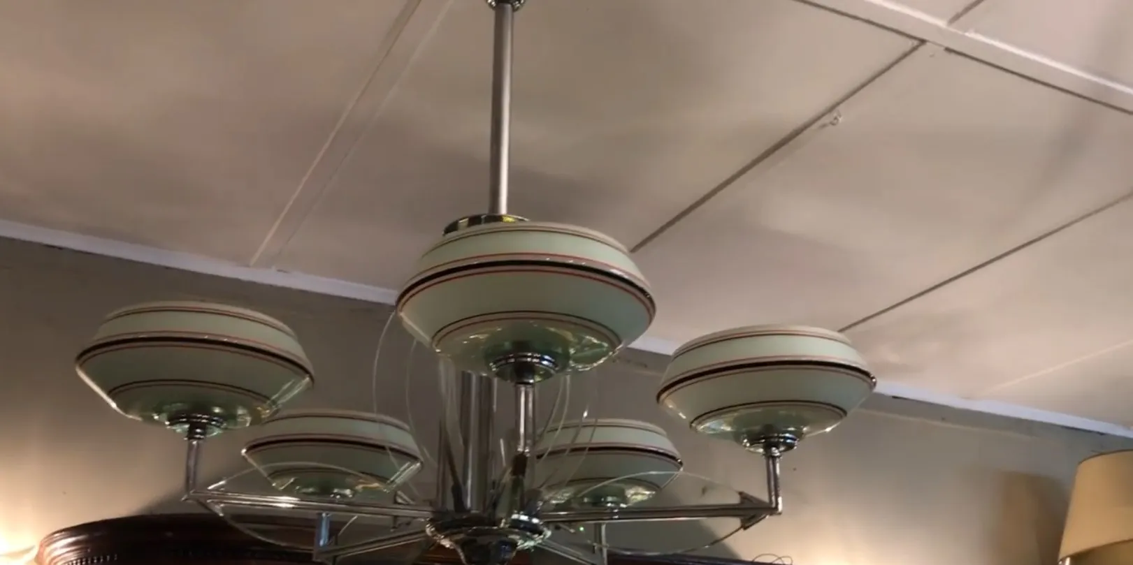 Lampada a sospensione antica con sei paralumi rotondi e dettagli eleganti.