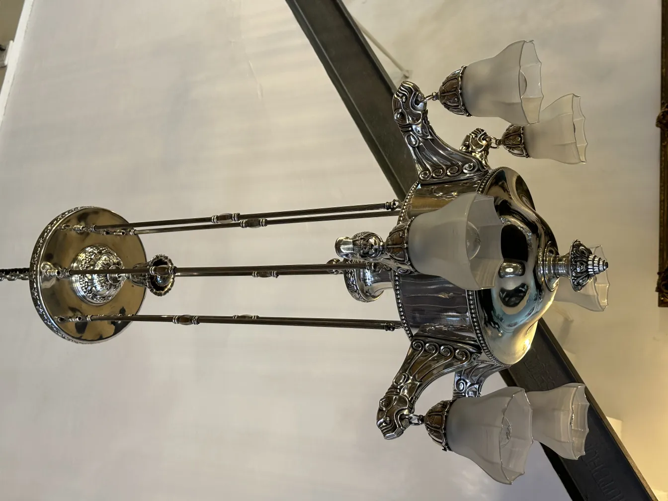 Antique hanging lamp with a silver base and glass shades.