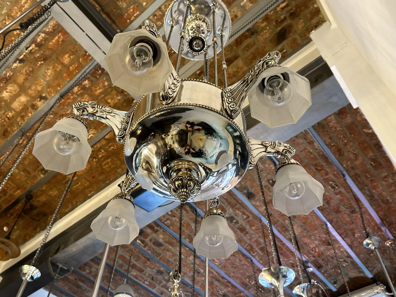 Lámpara de techo antigua con tonos claros y candelabro brillante.