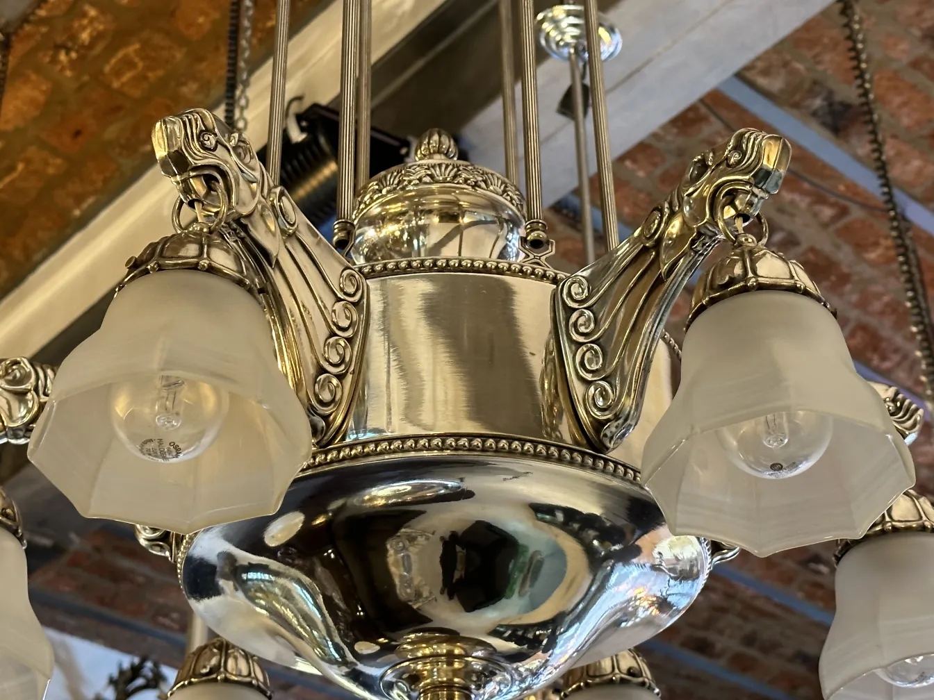 Antiga lâmpada de teto com design intricado, com sombras em forma de flor em um ambiente acolhedor.