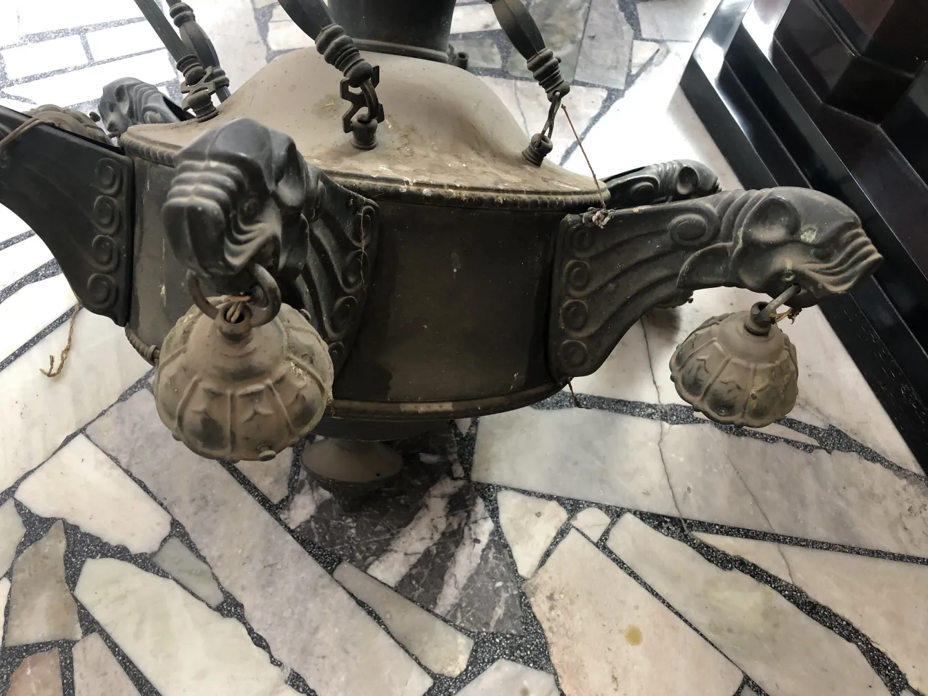 Antique hanging lamp with ornamental relief details, classic ambiance.