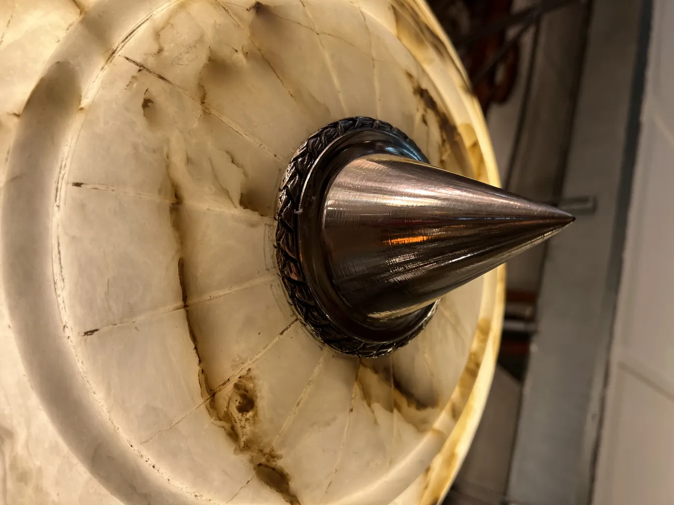 Lampada a sospensione antica in alabastro con dettagli decorativi. Atmosfera calda e accogliente.