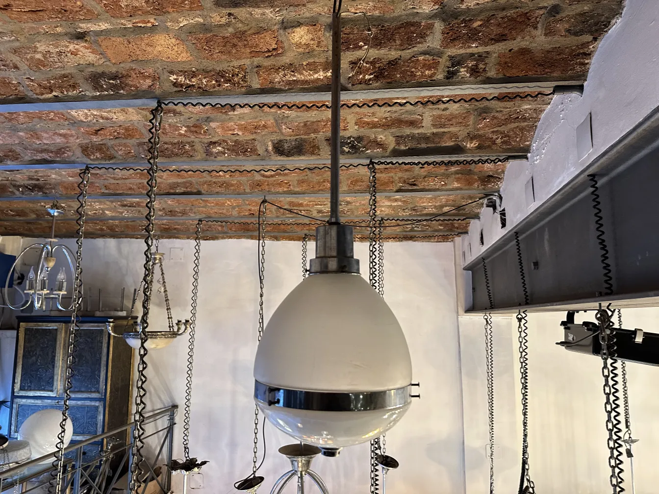 Lámpara de techo antigua en un ambiente rústico, con cadena.