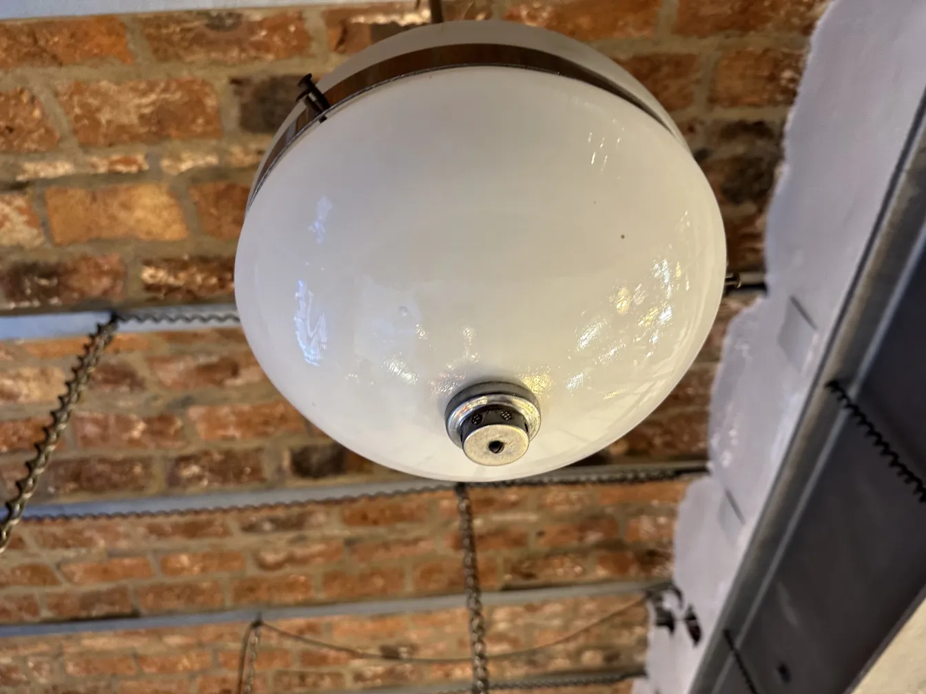 Lampada a sospensione antica, sfera bianca, atmosfera accogliente