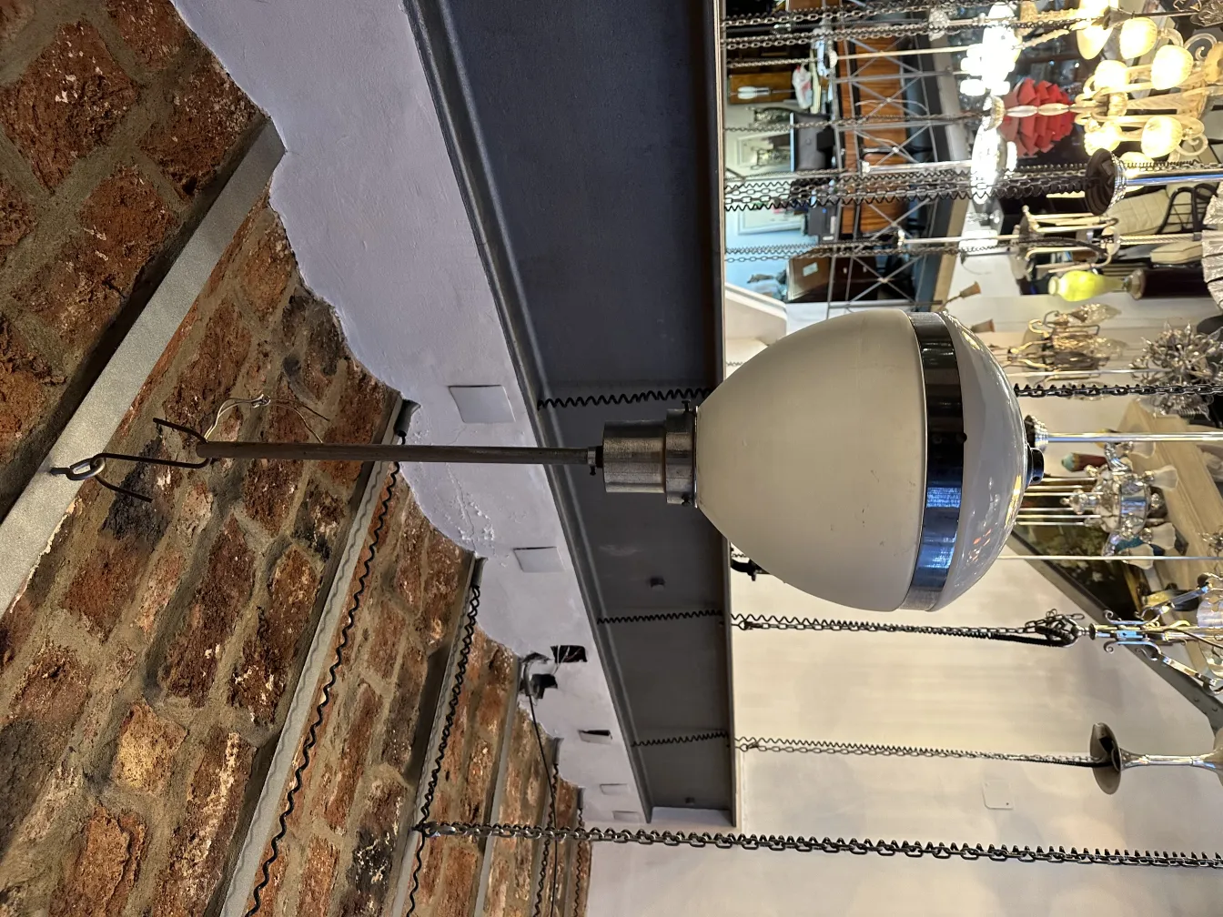 Lampada a sospensione antica, forma classica e design elegante, dettagli decorativi, in un ambiente accogliente.