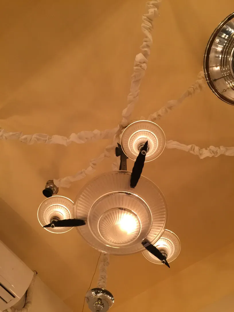 lampada de teto antiga com varios bracos em um ambiente aconchegante